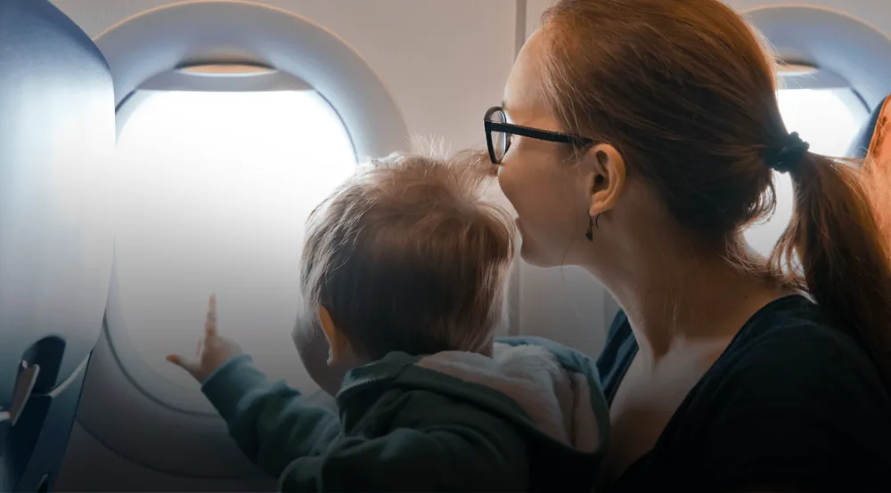 Mãe e filho olhando pela janela do avião