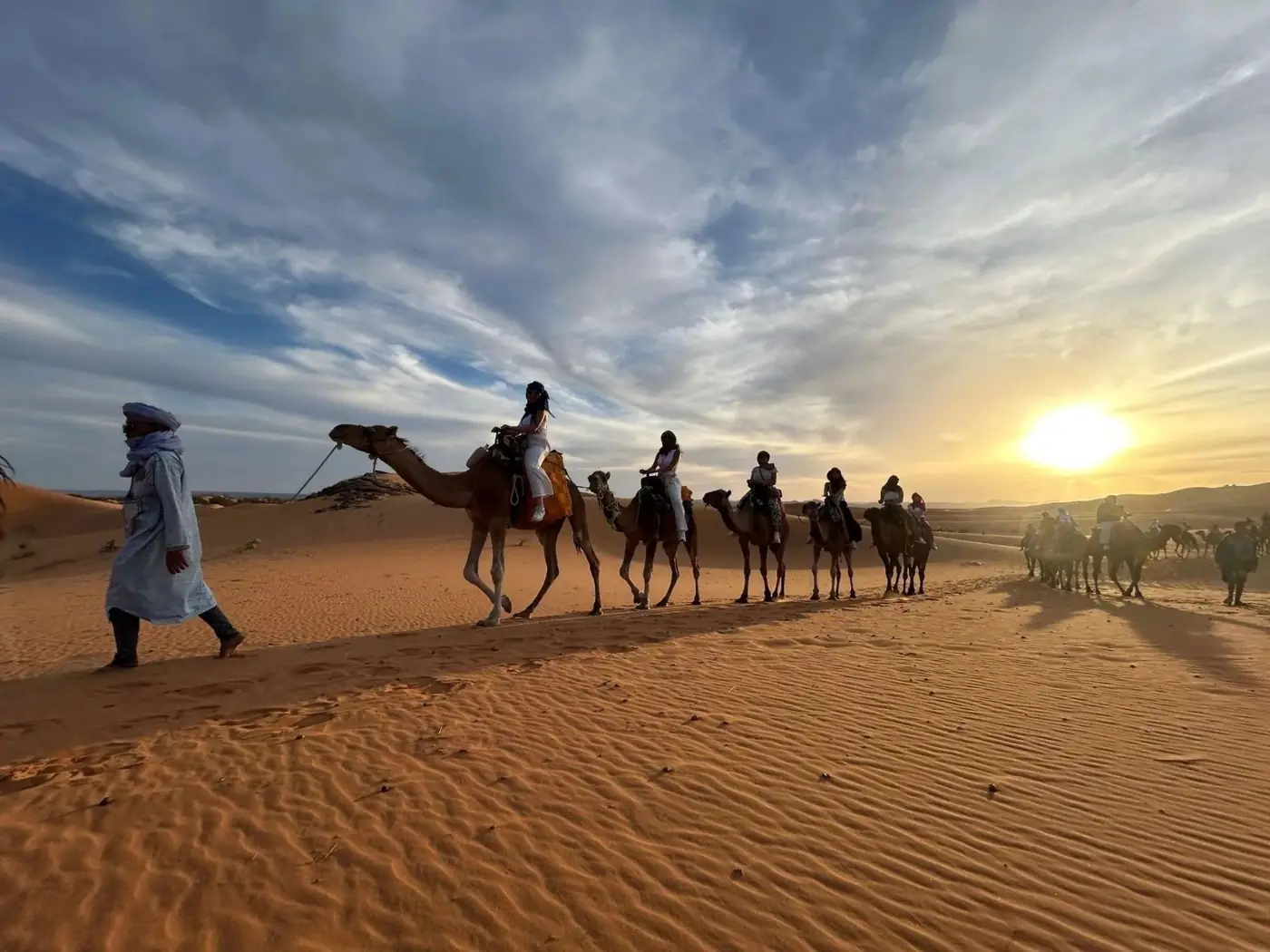 Caravana de camelos nas dunas de Merzouga ao pôr do sol
